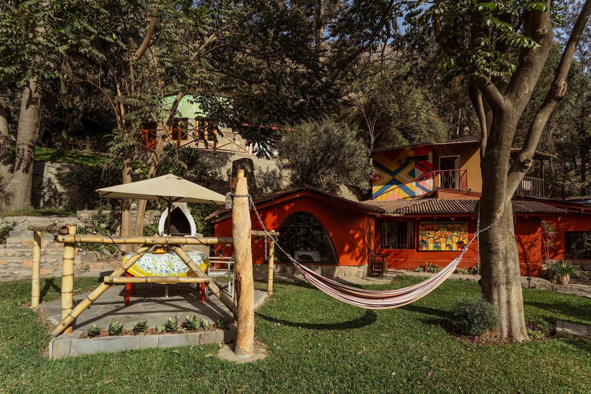 Jardín con hamaca y sombrilla frente a los bungalows